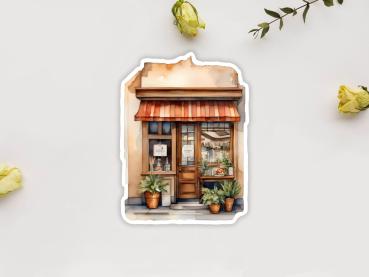 Sticker eines kleinen Geschäfts im mediterranen Stil mit rot-weiß gestreifter Markise. Im Schaufenster befinden sich Pflanzen in Tontöpfen und ein kleines Schild mit der Aufschrift 'Bakery'. Der Eingang ist von Pflanzen eingerahmt.